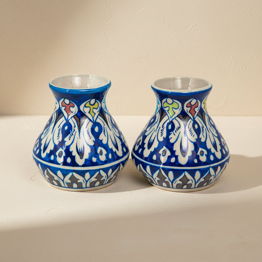 Two blue ceramic vases with white and multicolor patterns on a white background